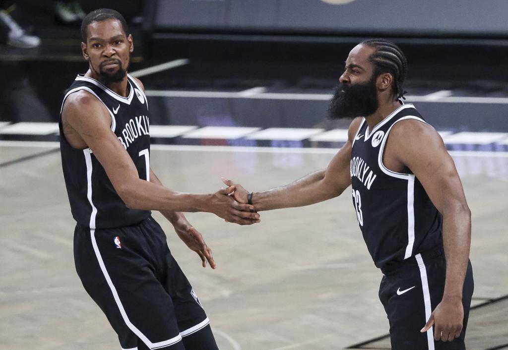 Kevin Durant and Kyrie Irving celebrate the Nets basket.