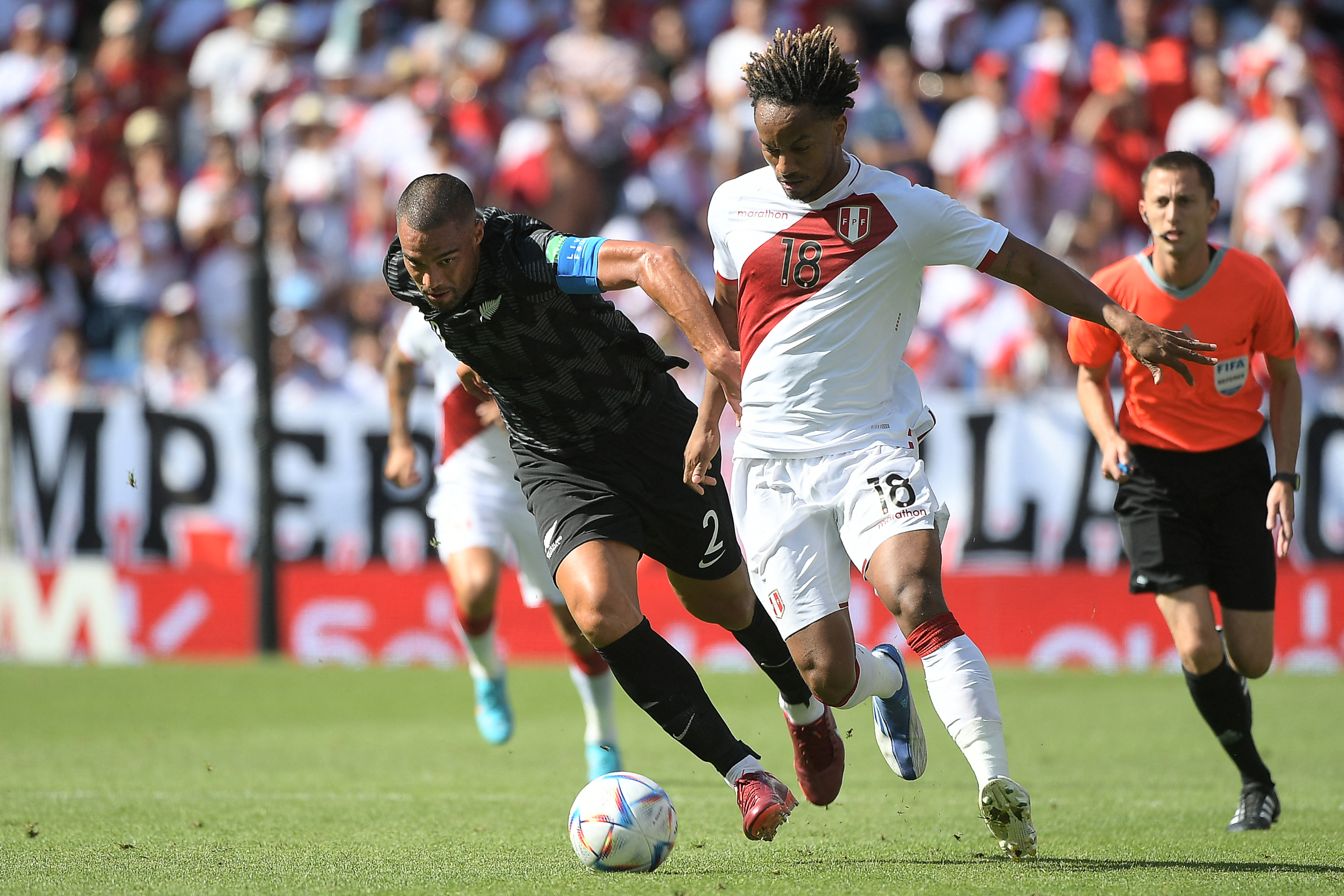 New Zealand defender Winston Reid (L) fights for the ball with Peru's Andre Carrillo during an international friendly football match between Peru and New Zealand on June 5, 2022 at the RCDE Stadium in Cornella de Lப்bracott.  (Photo by Jose Jordan / AFP)