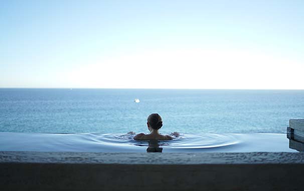 Young woman bathing in an infinity pool