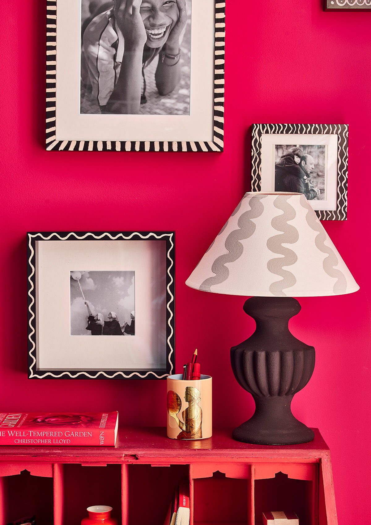 Pink wall with picture cabinet and lamp